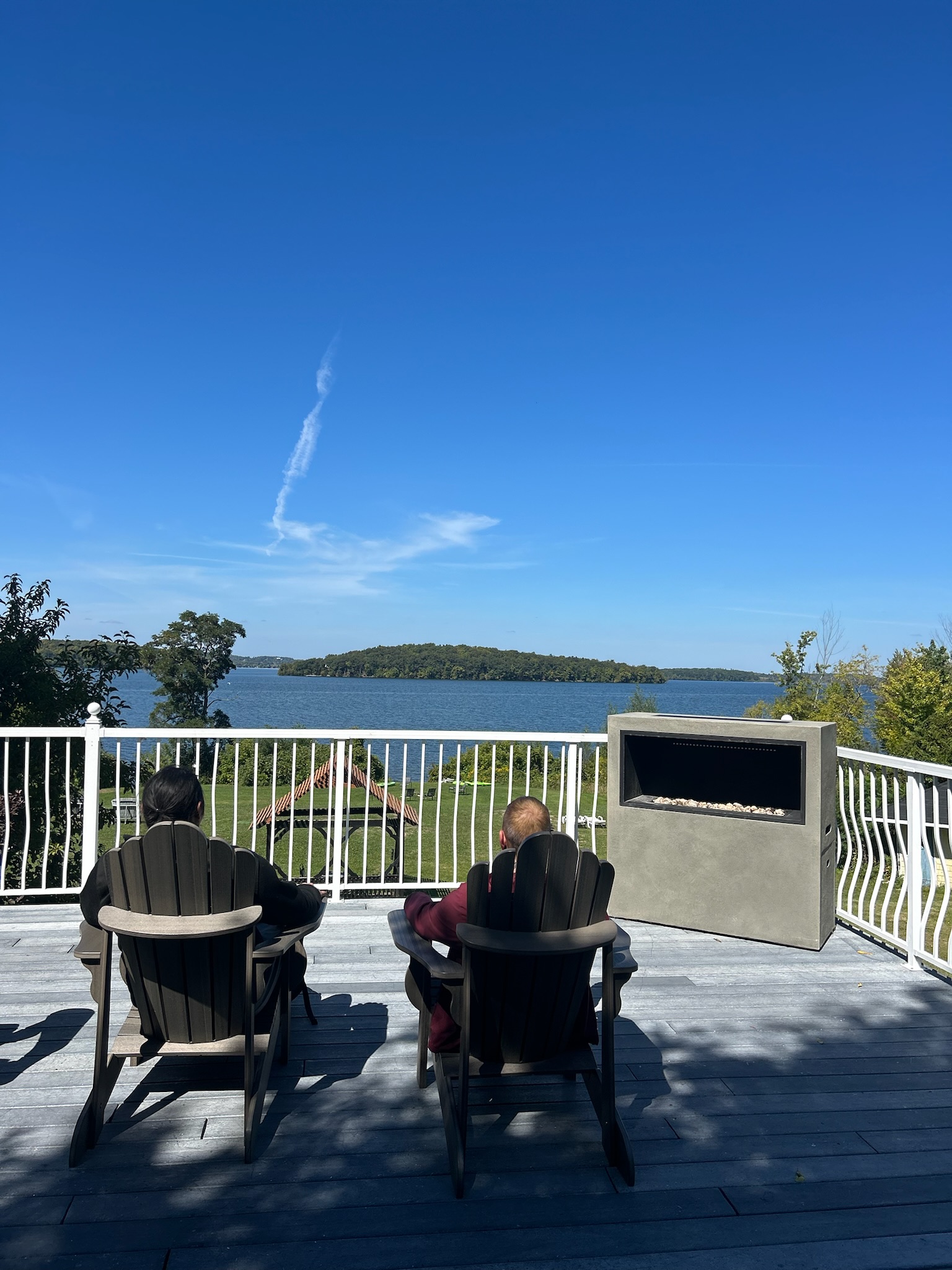 Relaxing by the outdoor fireplace overlooking the lake at Victoria Wellness